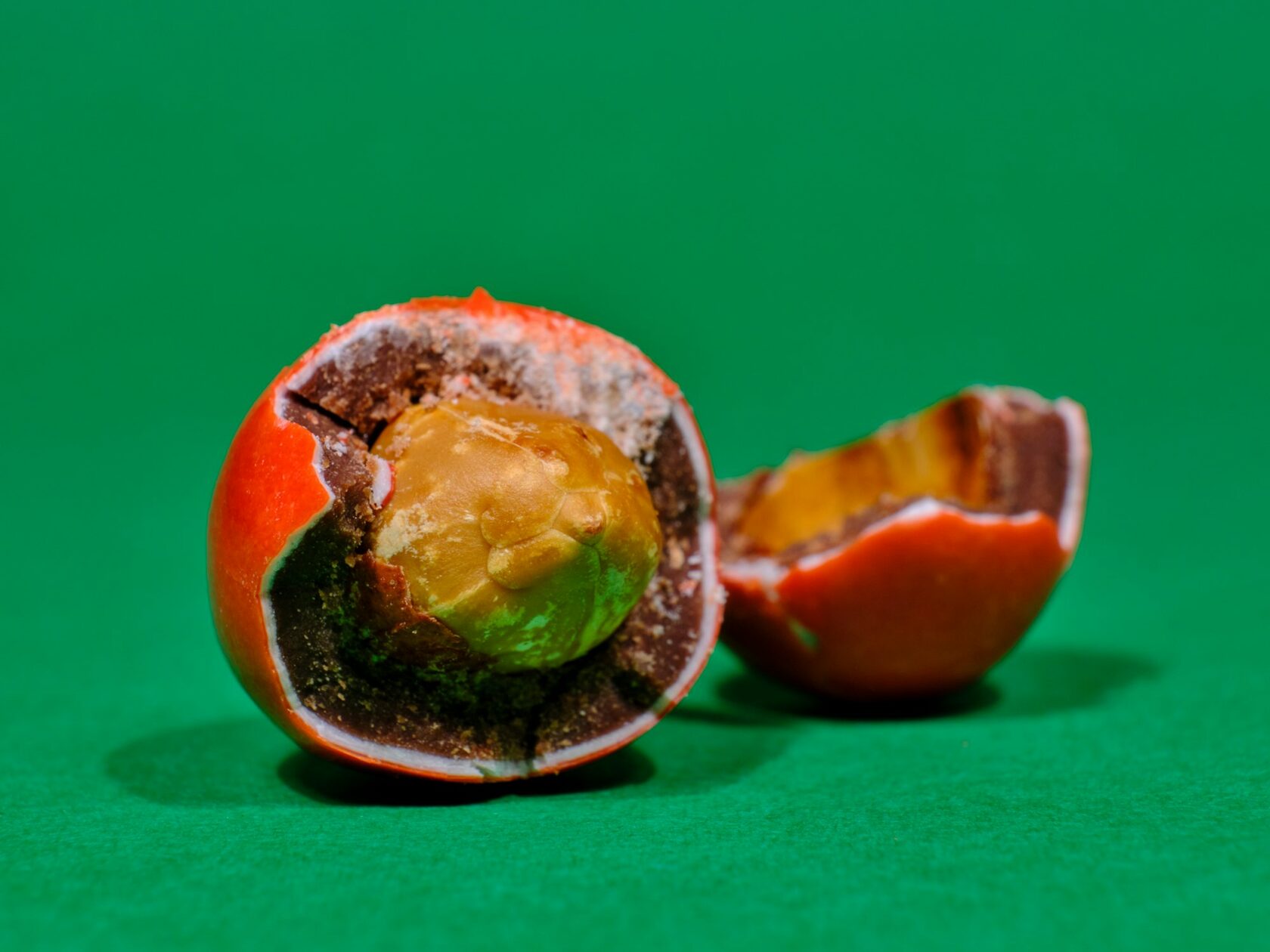 A round Coin Volcano candy cut in half, revealing the soft fruity filling inside